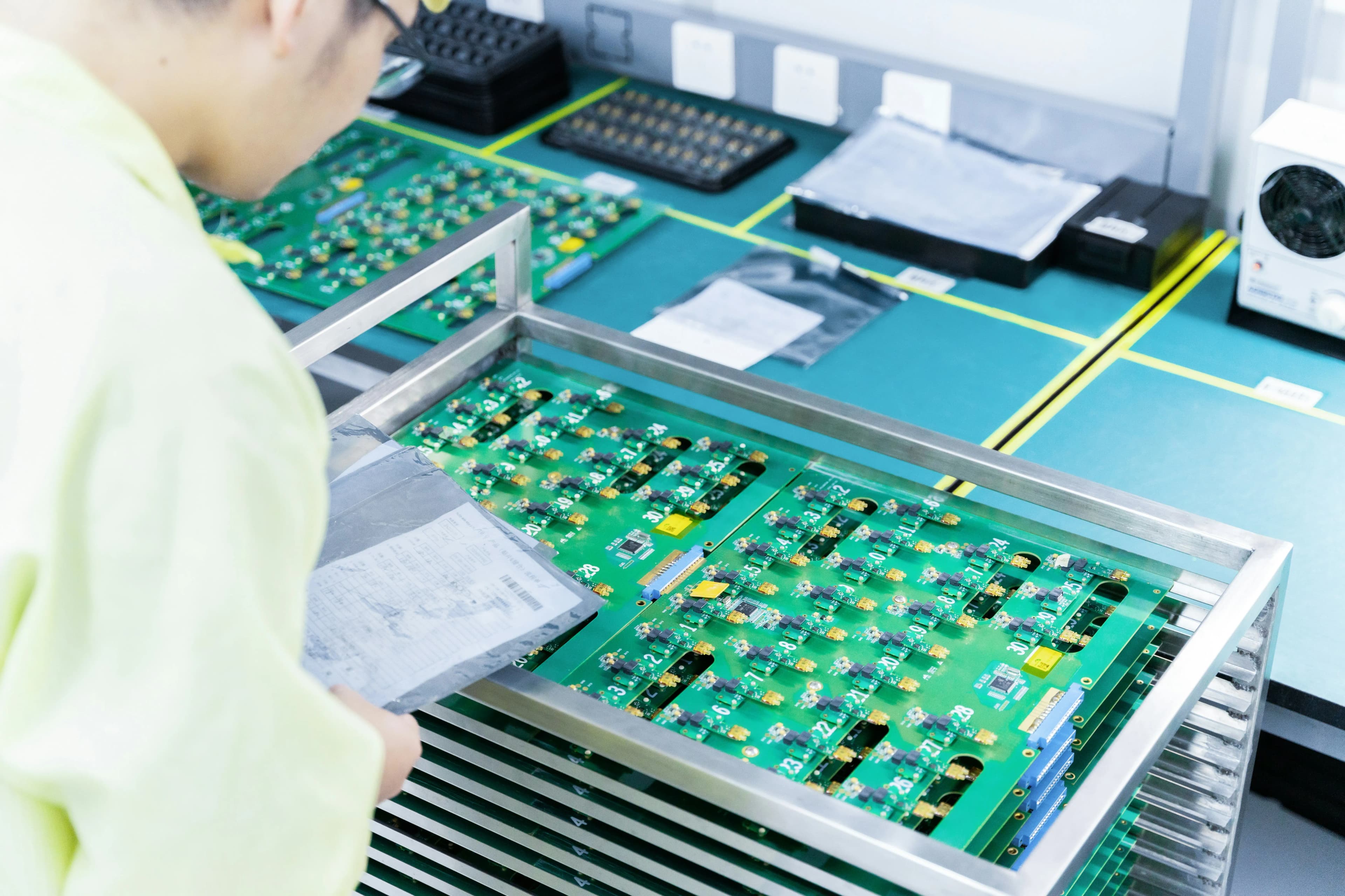 A man working on electronic components in a manufacturing facility